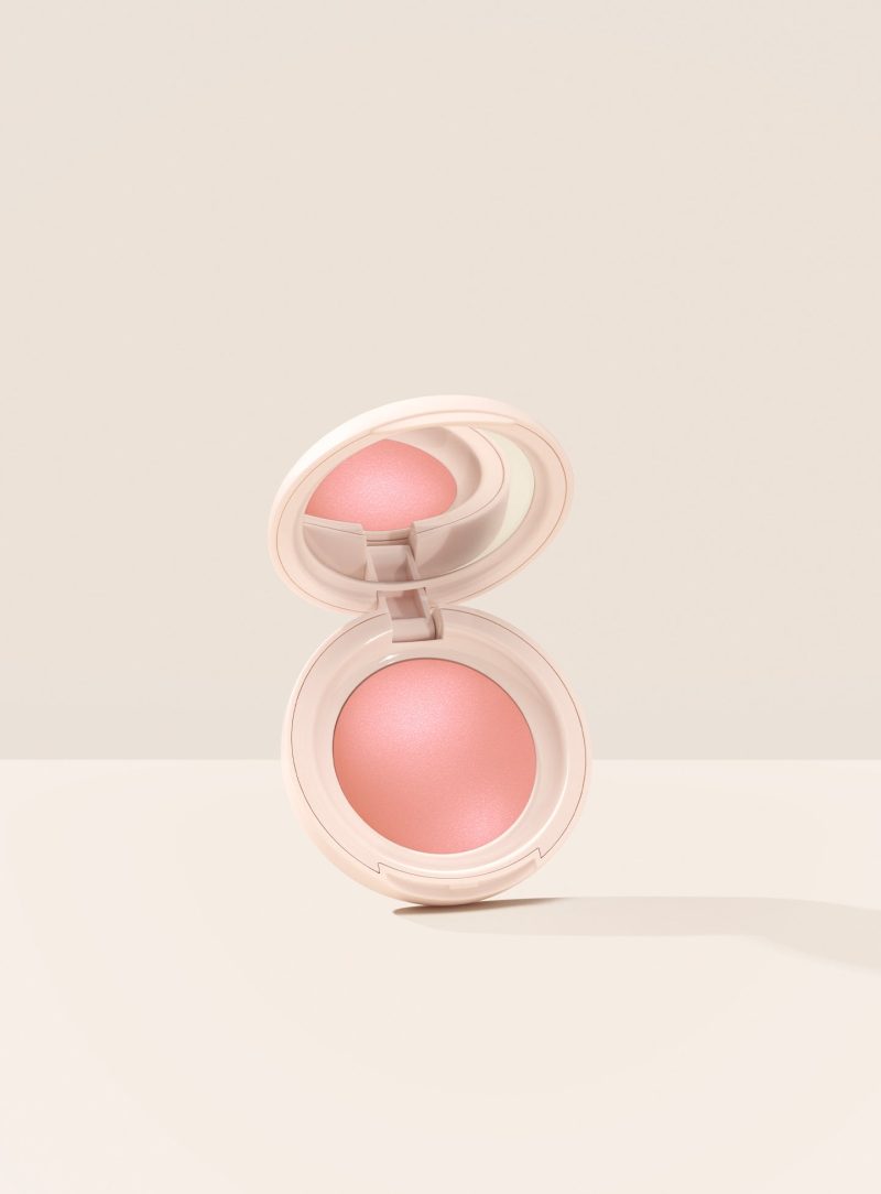 Cheer| Rare Beauty's Soft Pinch Luminous Powder Blush in the shade Cheer opened against a neutral background.