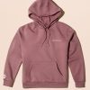 Rare Beauty's Comfy Hoodie mauve hooded sweatshirt laying against a neutral beige background.